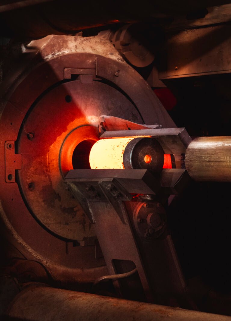 Workers hand-winding copper tube coils on the factory floor